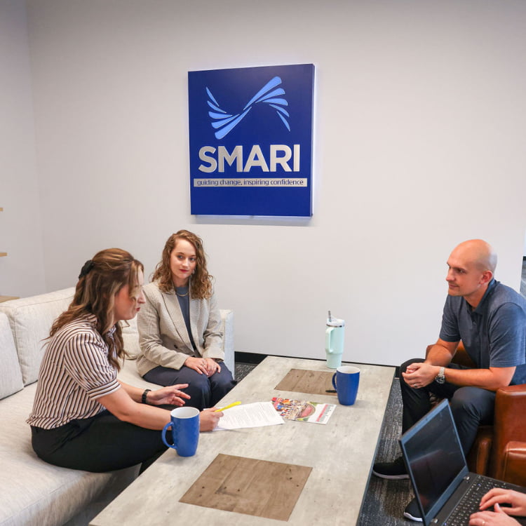 4 employees work at couches and chairs to discuss market research