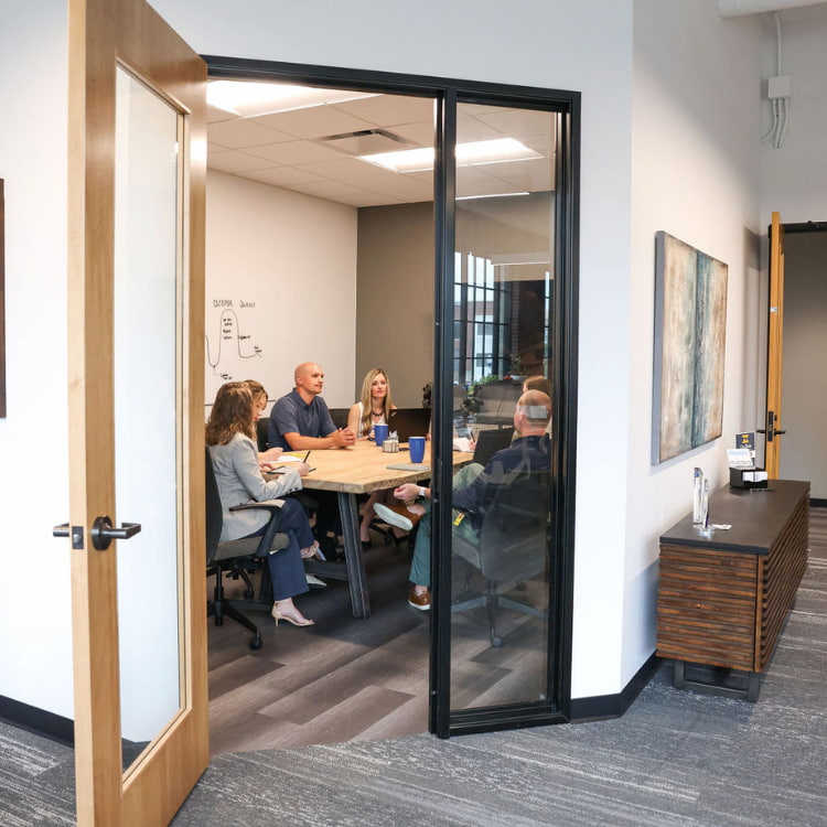 View inside the door of a conference room showing SMARI employees meeting about the customer journey
