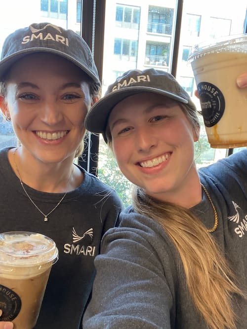 2 SMARI employees take a selfie with their iced coffees