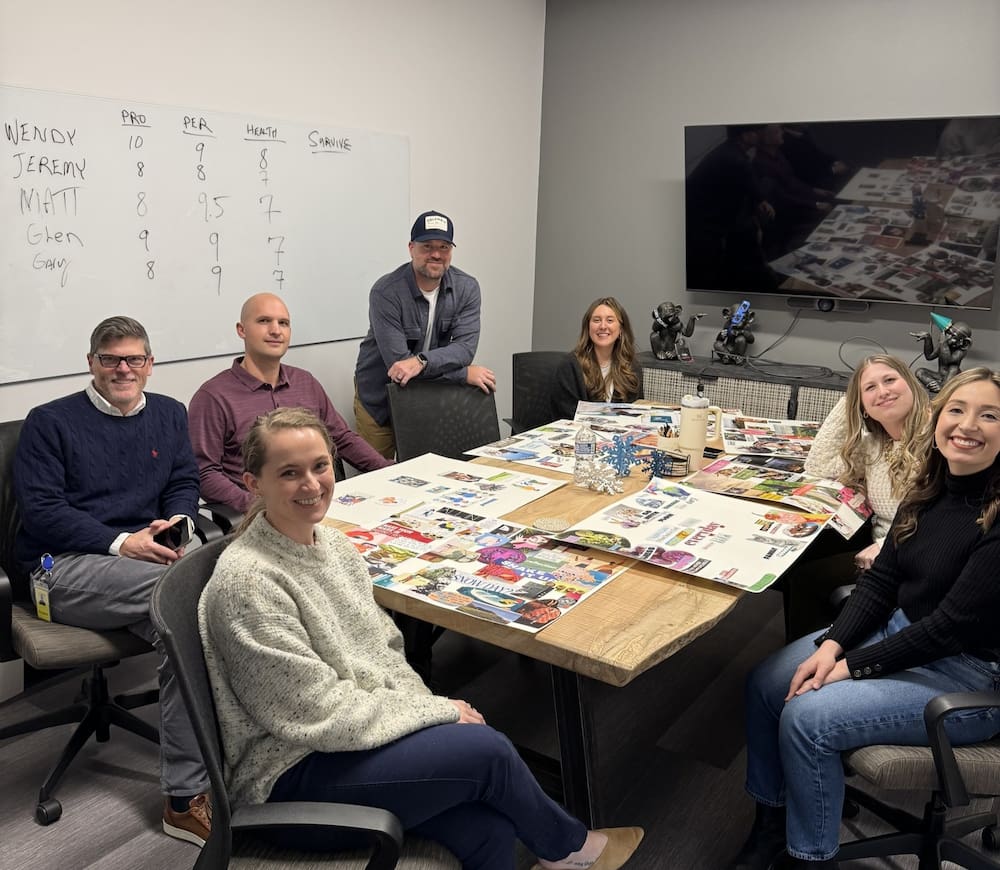 Employees making vision boards in a SMARI conference room for team bonding